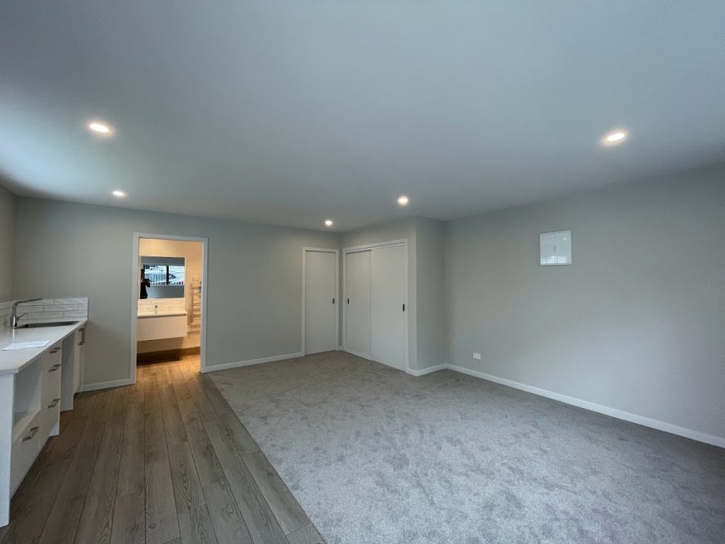 Garage conversion into a liveable room with kitchenette, ensuite and carpeted living area — Auckland renovation by Add Value Renovations