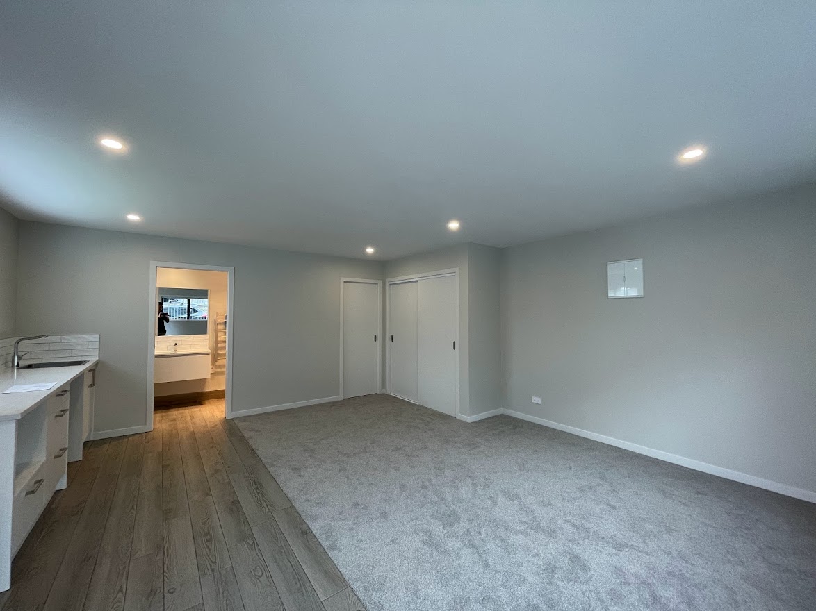 Garage conversion into a liveable room with kitchenette, ensuite and carpeted living area — Auckland renovation by Add Value Renovations