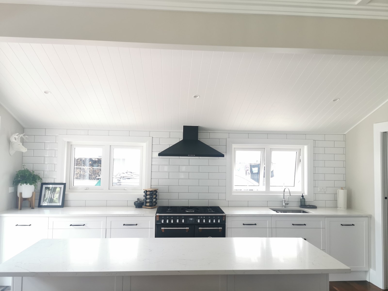 Heritage villa kitchen renovation Auckland with white Shaker cabinetry, subway tile splashback, VJ ceiling and Smeg range cooker