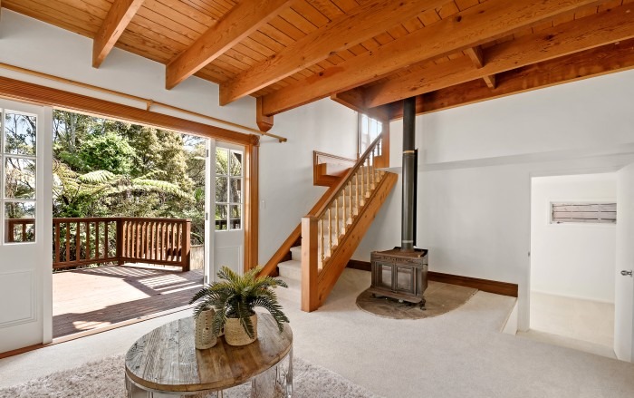 Lockwood entry living area with wood burner and timber staircase — Add Value Renovations Auckland