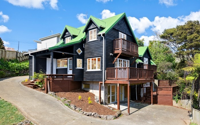 Classic Lockwood home exterior with dark timber cladding and green roof — Auckland renovation specialist
