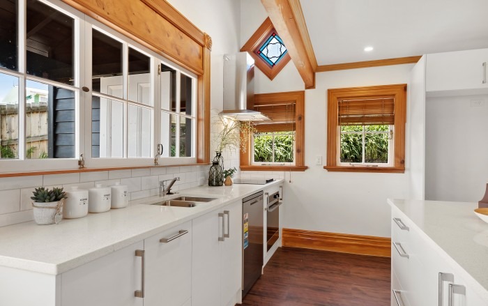 Renovated Lockwood galley kitchen with white cabinetry and original timber detailing