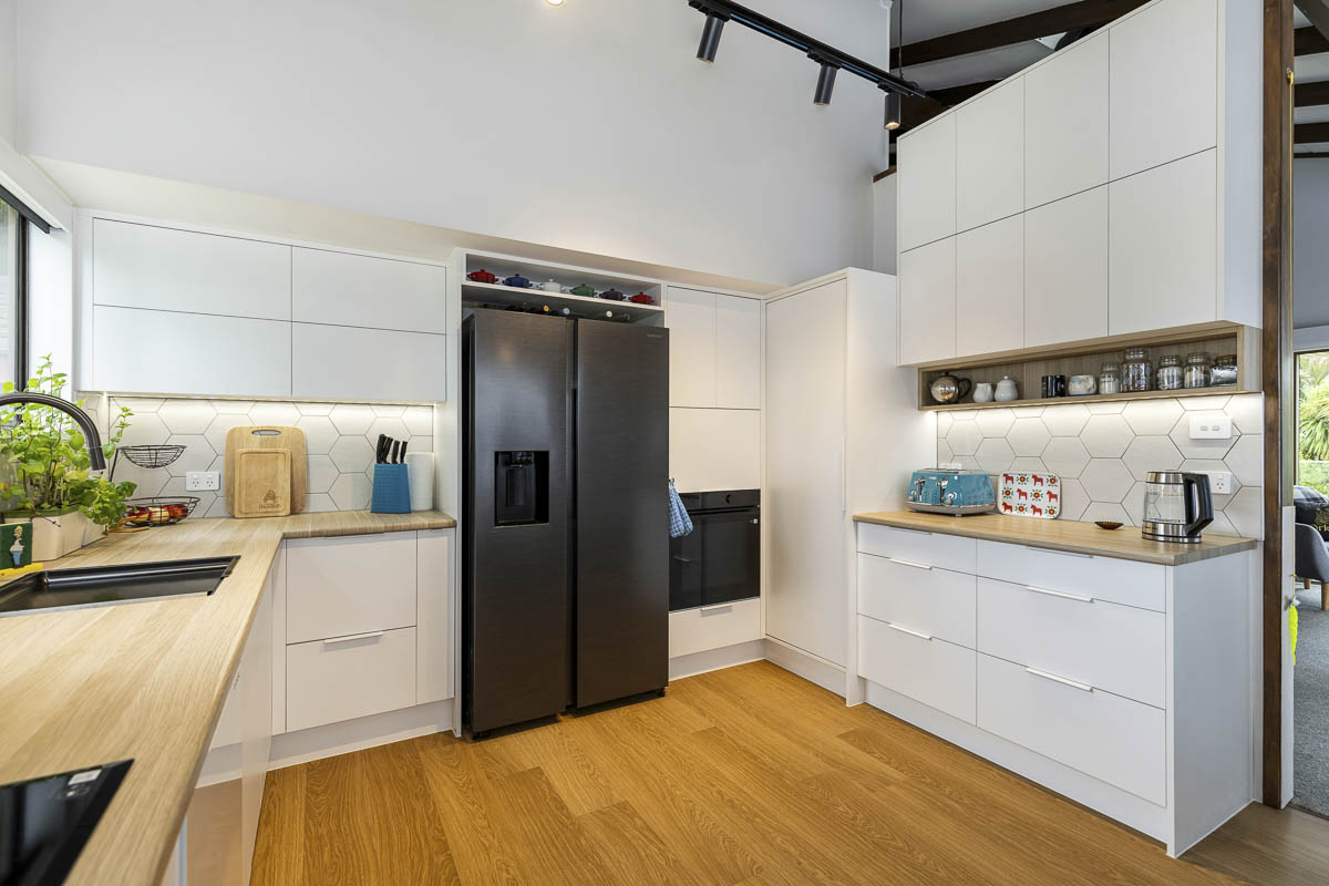 Lynfield kitchen wide view with integrated black fridge