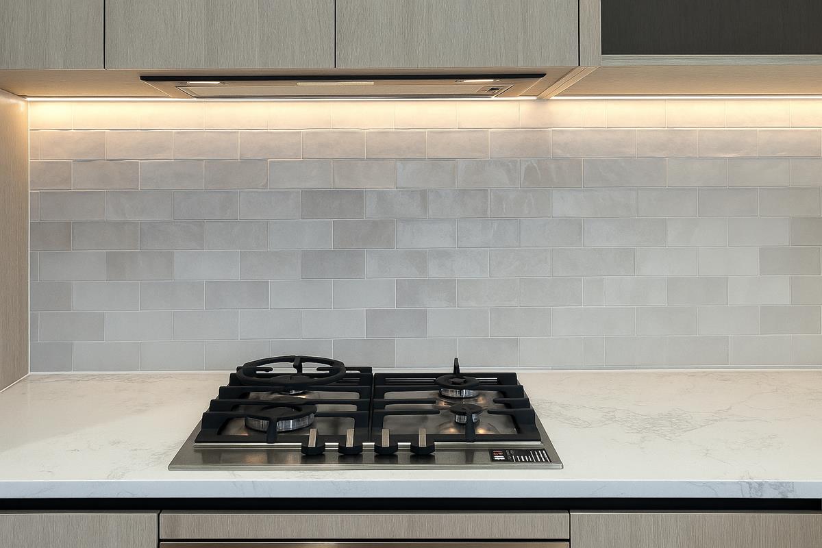 Built-in gas cooktop with tile splashback and marble-look benchtop — Mt Roskill kitchen renovation by Add Value Renovations