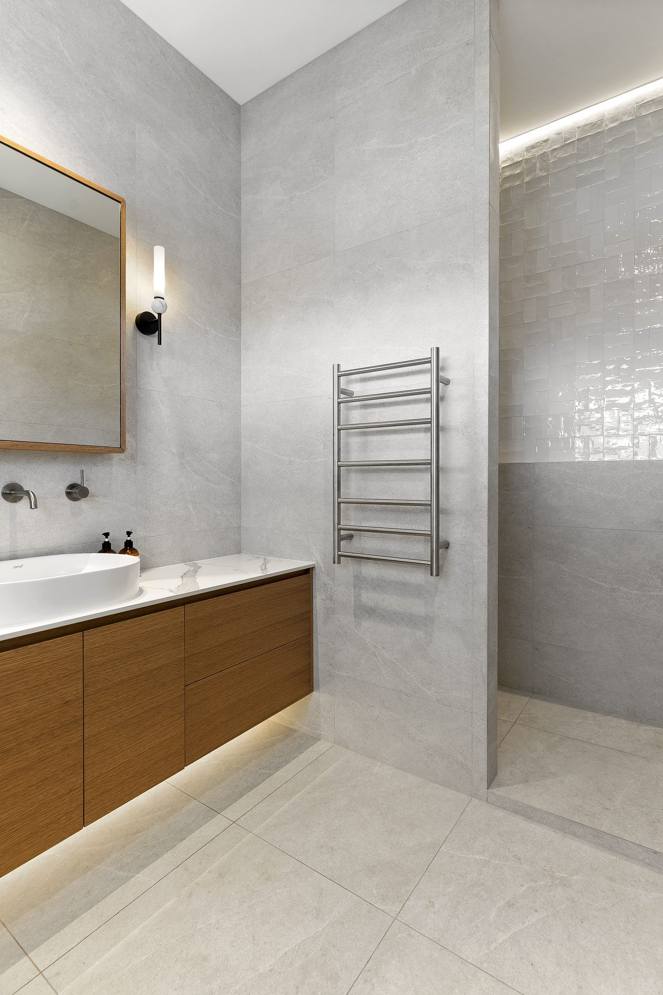 Walk-in shower with a ceiling strip light washing down the Fez White feature wall — Remuera ensuite