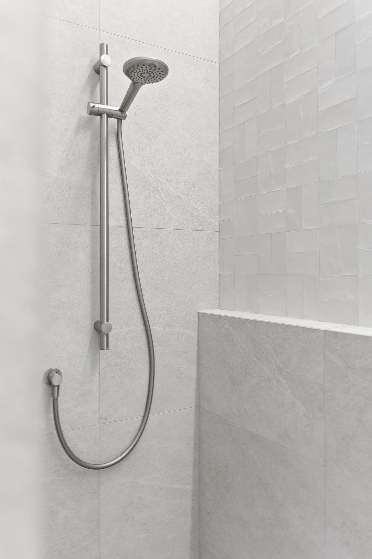 Walk-in shower with handheld rail and tiled bench seat — Remuera ensuite