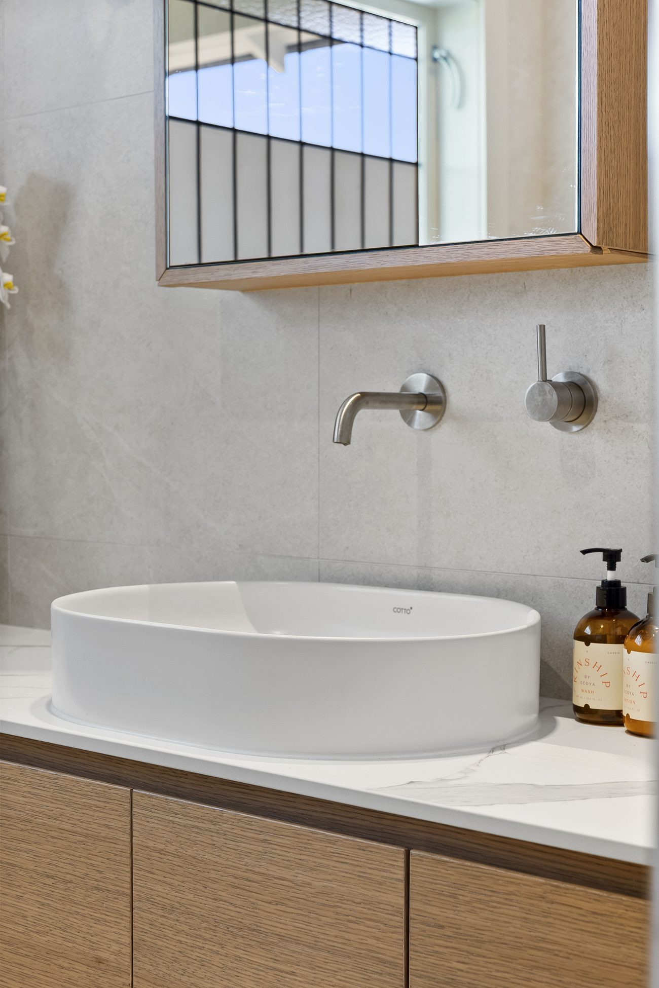 Brushed wall-mounted basin tapware over a Cotto basin and stone top — Remuera ensuite