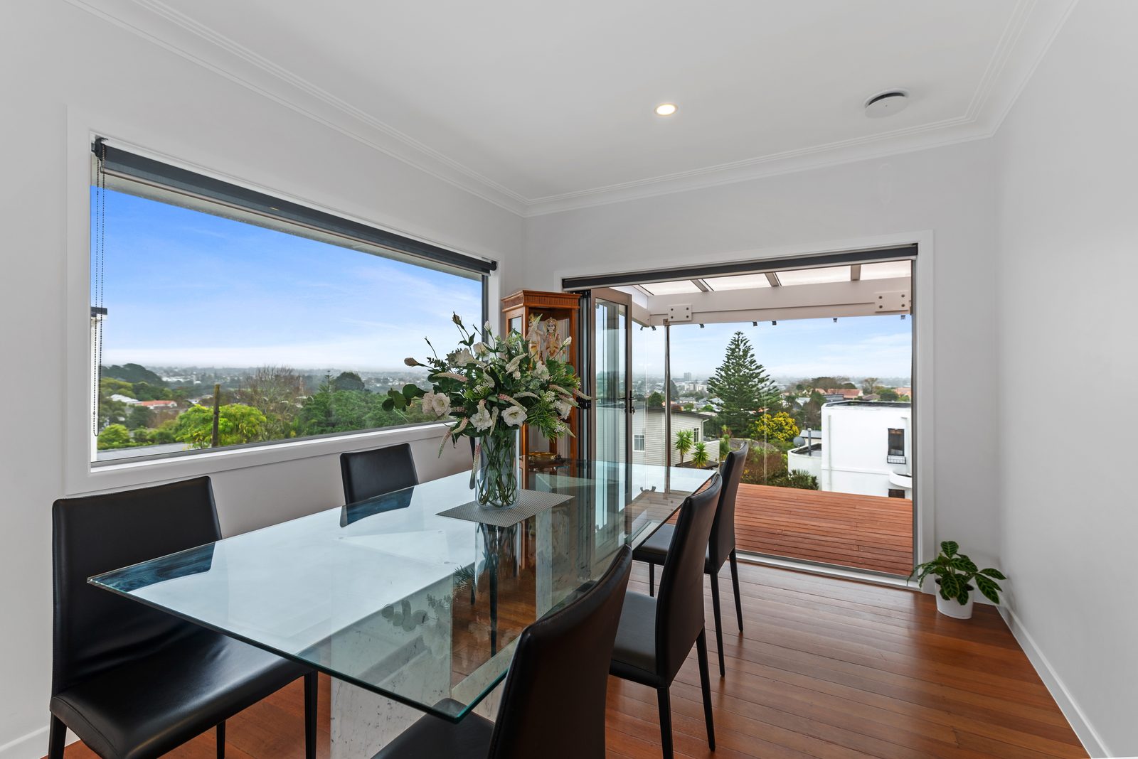Dining area opening to a deck with West Auckland views — Kishore family whole home renovation in Blockhouse Bay