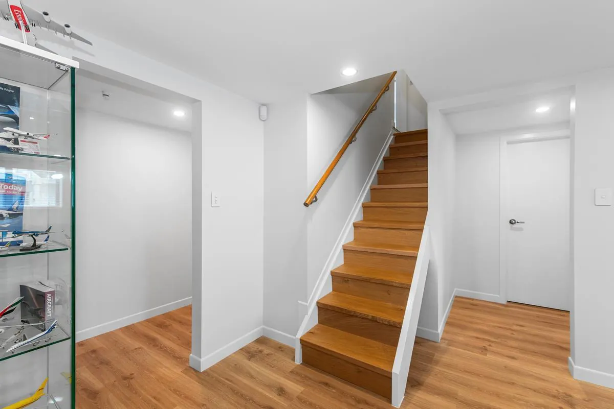 Modern-solid-timber-staircase-with-oak-handrail-and-black-steel-balustrade-–-family-home-interior-design.